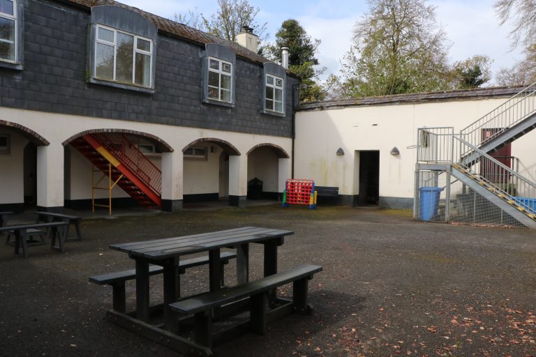 Courtyard with picnic tables. there is a set of steps leading to upstairs building.