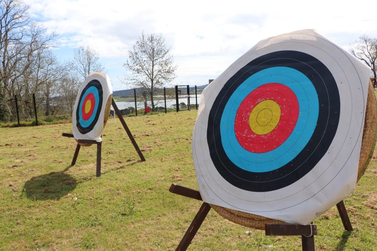 2 archery targets set up on a large grassy area