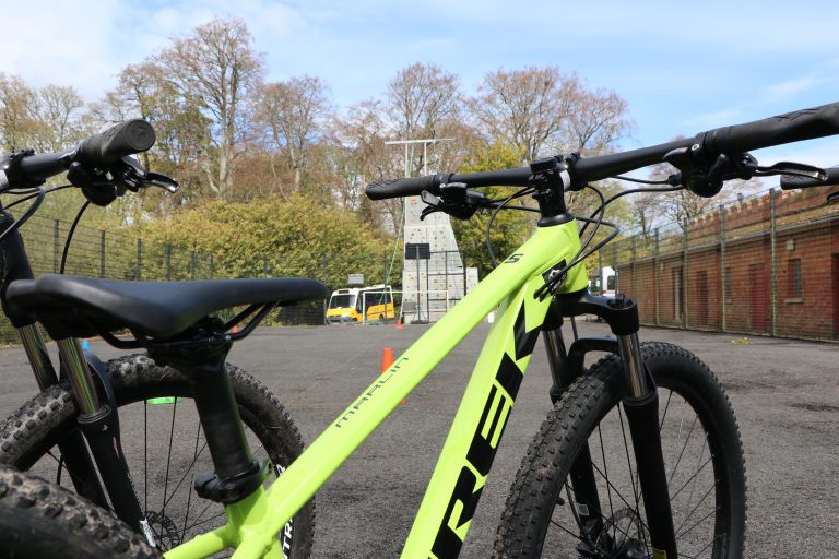 A green mountain bike with a climbing frame in the background